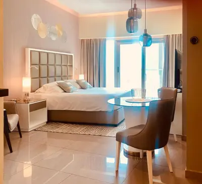 a bedroom with a bed and a table and a dining room at Premium Guest - Majestine Downtown Luxe in Dubai