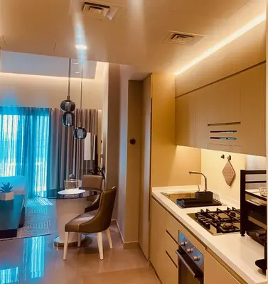 a kitchen with a sink and a table with a chair at Premium Guest - Majestine Downtown Luxe in Dubai
