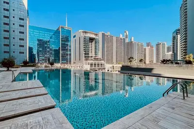 a large swimming pool in a city with tall buildings at Premium Guest - Majestine Downtown Luxe in Dubai