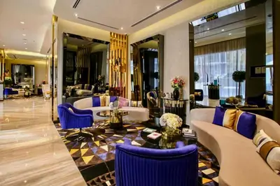 a lobby with couches and blue chairs in a building at Premium Guest - Majestine Downtown Luxe in Dubai