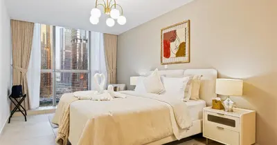 a white bedroom with a large bed and a window at Lake View 1BHK in JLT Next to Metro in Dubai