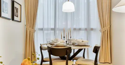 a dining room with a table with chairs and candles at Lake View 1BHK in JLT Next to Metro in Dubai