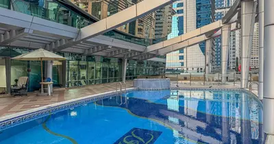 a large swimming pool in a building with tall buildings at Lake View 1BHK in JLT Next to Metro in Dubai