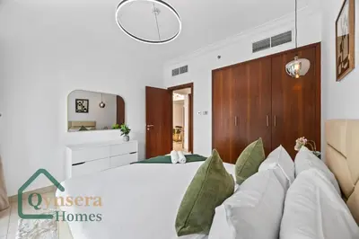 a bedroom with a large white bed with green pillows at Skyline Bliss Luxury Apartment Dubai in Dubai