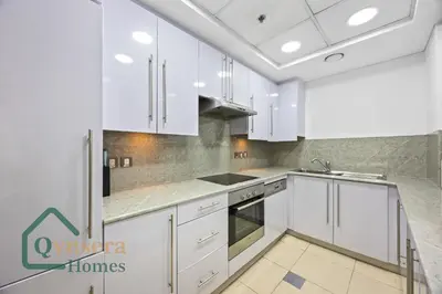 a white kitchen with white cabinets and a sink at Skyline Bliss Luxury Apartment Dubai in Dubai