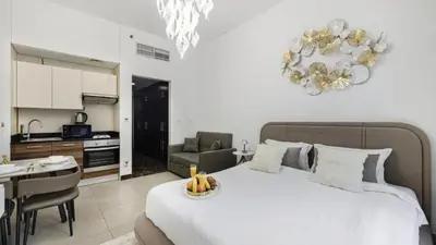 a bedroom with a large white bed and a kitchen at Sparkle Tower by Swarovski, Premium Full Marina View, 2min JBR & Metro, Sleeps 4 in Dubai