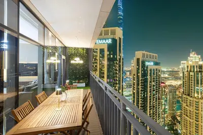 a balcony with a wooden table and chairs on a city skyline at Spacious Lux 4 Bed with Large Balcony and Burj View by Vista Stays Dubai in Dubai