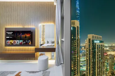 a room with a view of a city at night at Spacious Lux 4 Bed with Large Balcony and Burj View by Vista Stays Dubai in Dubai