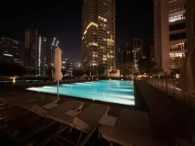 a swimming pool in a city at night at Spacious Lux 4 Bed with Large Balcony and Burj View by Vista Stays Dubai in Dubai