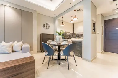 a dining room and kitchen with a table and chairs at Sky-High 2BR with City Views, Minutes Drive to Downtown, Steps from the Bus Stop, Nobles Tower, Business Bay by Deluxe Holiday Homes in Dubai