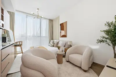 a living room with two chairs and a bed at Aura by Grovy Studio - Parking, Sauna&Gym, Pool - by Rentujemy in Dubai