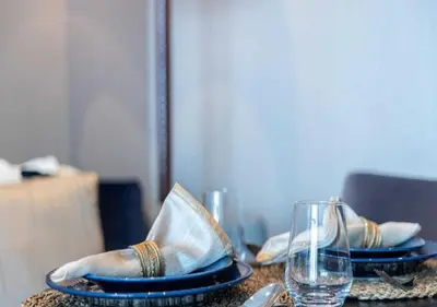 a table with two plates with napkins and a glass at Premium Living with Canal views and Top Notch Amenities in Dubai