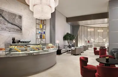 a lobby of a hotel with tables and chairs at Kempinski Central Avenue Residence Largest 1BR with Burj Khalifa View in Dubai