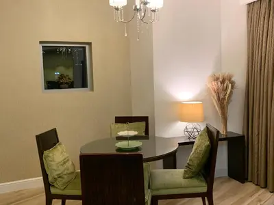 a dining room with a table and chairs and a chandelier at Kempinski Central Avenue Residence Largest 1BR with Burj Khalifa View in Dubai