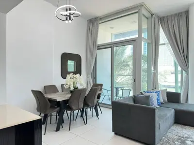 a living room with a couch and a table with chairs at Modern 2 Bedroom Apartment in Dubai Marina in Dubai