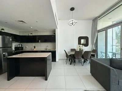 a kitchen and living room with a couch and a table at Modern 2 Bedroom Apartment in Dubai Marina in Dubai