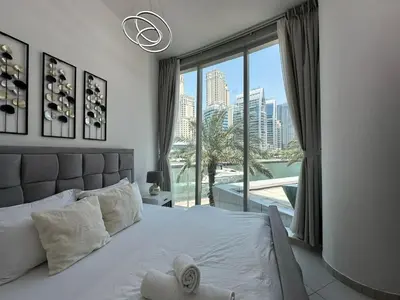 a bedroom with a bed with a view of a city at Modern 2 Bedroom Apartment in Dubai Marina in Dubai
