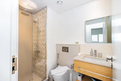 a bathroom with a toilet and a sink and a shower at Escape24 Contemporary 1BR with City Views in Dubai Hills in Dubai