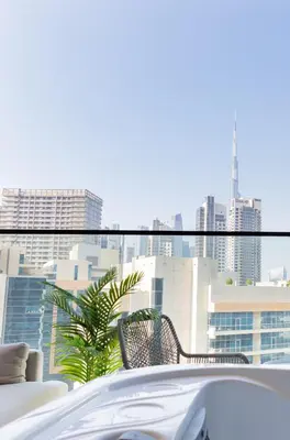 a white car on a balcony with a view of a city at Luxury Studio - Private Jacuzzi & Burj Khalifa View in Dubai