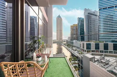 a balcony with chairs and a view of a river at Brand New Building! 2 Double Bed! Ideal Location with 5-star Pool and Gym! in Dubai
