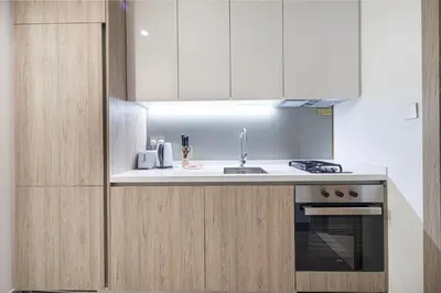 a kitchen with a sink and a stove at Brand New Building! 2 Double Bed! Ideal Location with 5-star Pool and Gym! in Dubai