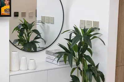 a bathroom with a mirror and a plant at Brand New Building! 2 Double Bed! Ideal Location with 5-star Pool and Gym! in Dubai