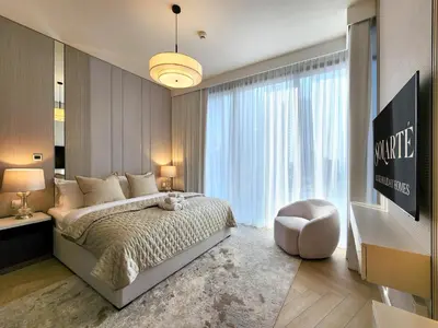 a bedroom with a large bed and a chair at SOLARTE Luxe - LIV Marina - Premium 2BR Residence in Dubai