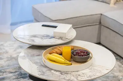 two tables with a tray of fruit on top of it at Elegant 2BR With Modern Design Near to Circle Mall in Dubai