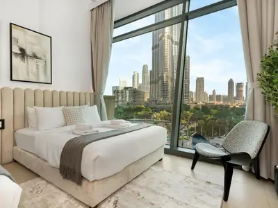a bedroom with a bed and a large window at Stunning 4BR Burj View Pool &Gym in Dubai