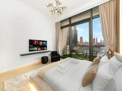 a bedroom with a large white bed and a large window at Stunning 4BR Burj View Pool &Gym in Dubai