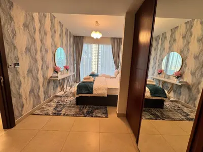a bedroom with two beds and two mirrors at Free Infiniti Pool and Jacuzzi - Marina Gate Luxury Stay - Enjoy Dubai Marina Views in Dubai