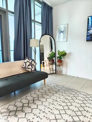 a living room with a bed and a mirror at Stylish JLT Apartment - Marina Skyline View - Next to Metro - Walk to Beach in Dubai