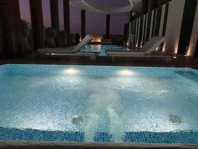 a large swimming pool with chairs in a hotel at Dubai corner at Westwood Imtiaz 1BR apartment in Dubai