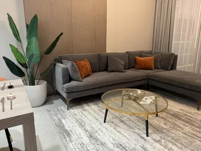 a living room with a couch and a glass table at Dubai corner at Westwood Imtiaz 1BR apartment in Dubai