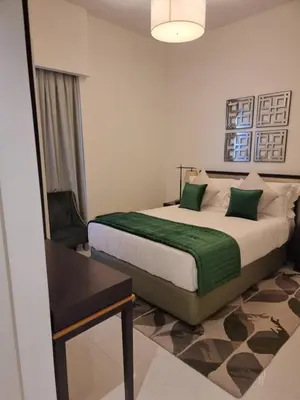 a bedroom with a large bed with a green blanket at شقة بالجي في سي Spacious apartment in Damac Ghalia JVC, Dubai in Dubai