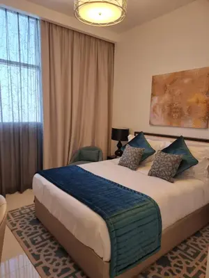 a bedroom with a large bed with a blue blanket at شقة بالجي في سي Spacious apartment in Damac Ghalia JVC, Dubai in Dubai