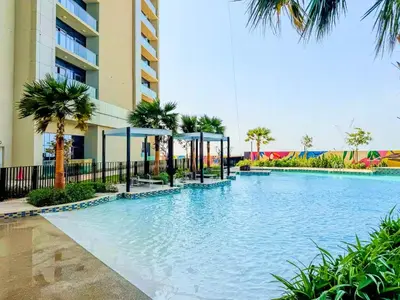 a swimming pool in front of a building with palm trees at Vogue Business Bay Aykon City Close to Downtown Burj Khalifa and Dubai Mall Burj Khalifa and Dubai Mall, One Bedroom Apartment with Balcony and City View, Access to all Amenities in Dubai