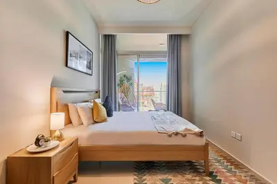 a bedroom with a large bed and a window at Modern 2BR Retreat Canal Views Near Downtown in Dubai