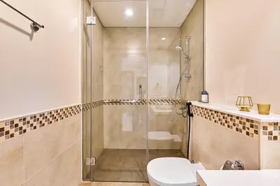 a bathroom with a shower and a toilet at Modern 2BR Retreat Canal Views Near Downtown in Dubai