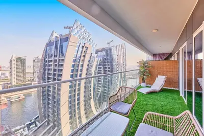 a balcony with chairs and a view of the city at Modern 2BR Retreat Canal Views Near Downtown in Dubai