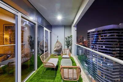 a balcony with chairs and tables and a city skyline at Modern 2BR Retreat Canal Views Near Downtown in Dubai