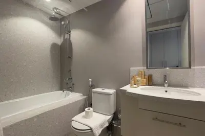 a bathroom with a sink and a toilet and a bath tub at Elite LUX Holiday Homes - Cozy City Escape in Standpoint Downtown in Dubai