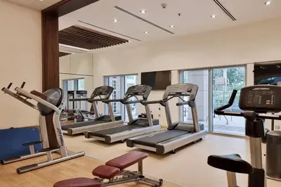 a gym with several tread machines in a room at Elite LUX Holiday Homes - Cozy City Escape in Standpoint Downtown in Dubai