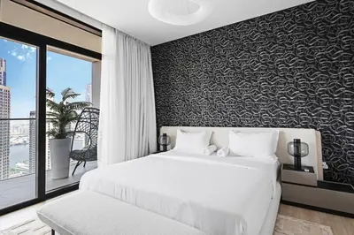 a bedroom with a white bed and a black wall at Creek Escape - Palace Residences - Creek Harbour in Dubai