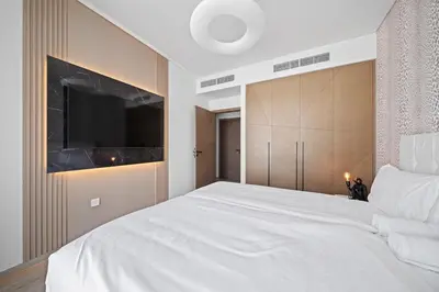 a bedroom with a large white bed and a tv at Creek Escape - Palace Residences - Creek Harbour in Dubai