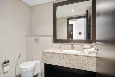 a bathroom with a sink and a toilet and a mirror at Palm Retreat - Anantara North - Palm Jumeirah in Dubai