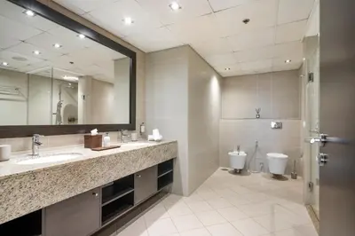 a bathroom with two sinks and a mirror and a toilet at Palm Retreat - Anantara North - Palm Jumeirah in Dubai