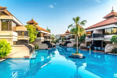 a resort pool with a palm tree in the middle at Palm Retreat - Anantara North - Palm Jumeirah in Dubai