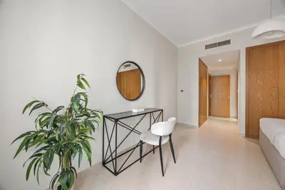 a bedroom with a plant and a table and a mirror at SanctuaryStays - A Luxury apartment with Full Burj Khalifa and Dubai Fountain Views - Dubai Mall Access in Dubai