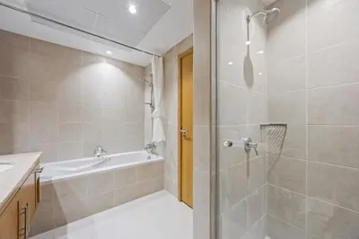 a bathroom with a shower and a tub and a sink at SanctuaryStays - A Luxury apartment with Full Burj Khalifa and Dubai Fountain Views - Dubai Mall Access in Dubai